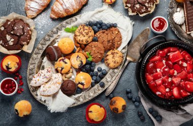 Pasta ve atıştırmalıklarla dolu bir tatlı masası. Çikolata. Kutlama konsepti. Üst manzara, düz uzanma