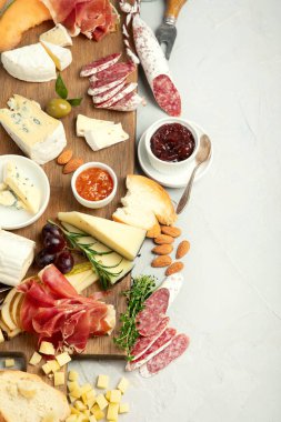 Hafif arka planda peynir çeşitleri. Gurme aperatifleri tepside. İtalyan yemeği konsepti. Üst görünüm, düz görünüm, kopyalama alanı