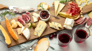 Hafif arka planda peynir çeşitleri. Gurme aperatifleri tepside. İtalyan yemeği konsepti. Üst manzara, düz uzanma