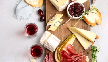 Hafif arka planda peynir çeşitleri. Gurme aperatifleri tepside. İtalyan yemeği konsepti. Üst görünüm, düz görünüm, kopyalama alanı