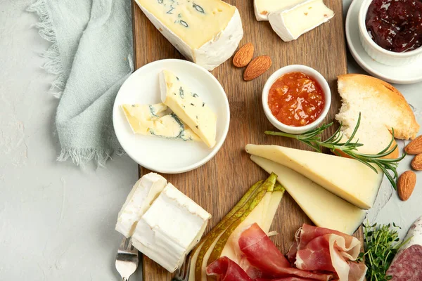 Hafif arka planda peynir çeşitleri. Gurme aperatifleri tepside. İtalyan yemeği konsepti. Üst görünüm, düz görünüm, kopyalama alanı