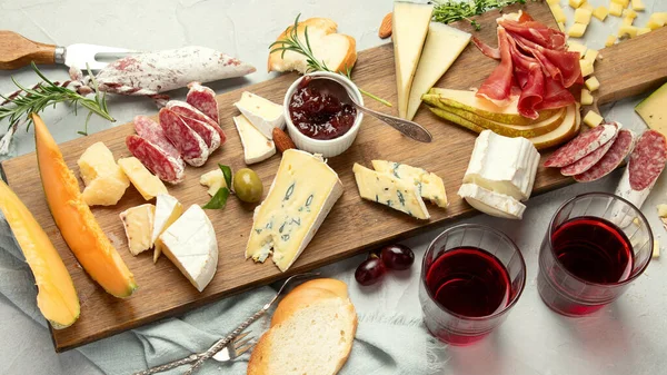 Hafif arka planda peynir çeşitleri. Gurme aperatifleri tepside. İtalyan yemeği konsepti. Üst manzara, düz uzanma