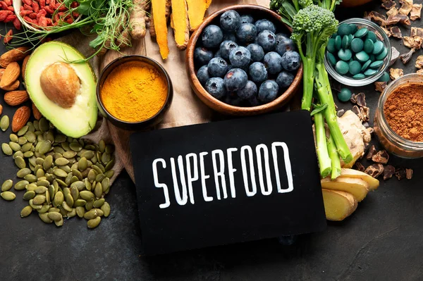 Sağlıklı yiyecekler, temiz yemek seçimleri, karanlık arka planda. Dengeli diyet konsepti. Süper yemek çeşitleri. Üst görünüm, düz görünüm, kopyalama alanı