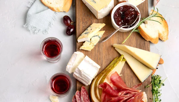 Hafif arka planda peynir çeşitleri. Gurme aperatifleri tepside. İtalyan yemeği konsepti. Üst görünüm, düz görünüm, kopyalama alanı