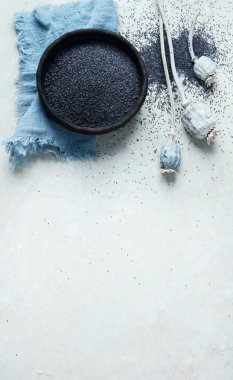 Gri arka planda haşhaş tohumlu kompozisyon. Organik gıda konsepti. Üst görünüm, düz görünüm, kopyalama alanı