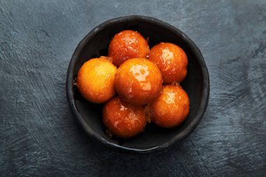 Gulab Jamun 'un gri arka planı. Geleneksel doğu yemekleri konsepti. Hint tatlıları. Üst manzara, düz uzanma