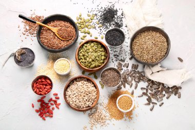 Variety of edible seeds on light background. Cereal and grains. Healthy food concept. Top view, flat lay