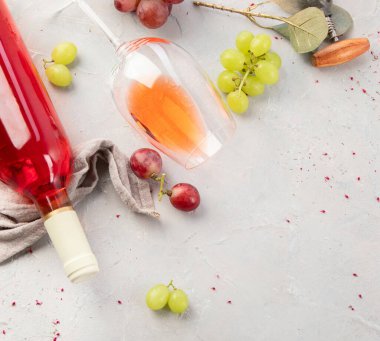 Gri arka planda bir şişe gül şarabı. Parti için yaz içeceği, şarap dükkanı ya da şarap tatma konsepti. Düz konum, üst görünüm, kopyalama alanı