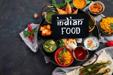 Indian Thali on dark background. Traditional food concept. Organic food concept. Dishes and appetisers of indeed cuisine. Top view, flat view, copy space