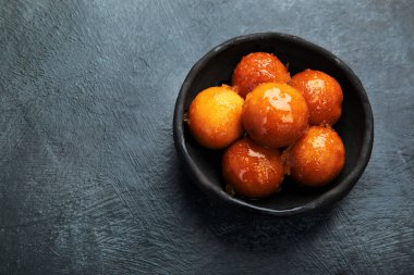 Gulab Jamun 'un gri arka planı. Geleneksel doğu yemekleri konsepti. Hint tatlıları. Üst görünüm, düz görünüm, kopyalama alanı