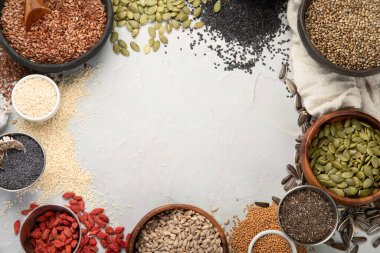 Hafif arka planda yenilebilir tohumların çeşitliliği. Tahıl ve tahıl. Sağlıklı gıda konsepti. Üst görünüm, düz görünüm, kopyalama alanı