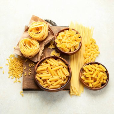 Hafif arka planda İtalyan makarnası. Geleneksel gıda konsepti. F lat lay, üst görünüm