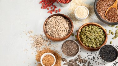 Hafif arka planda yenilebilir tohumların çeşitliliği. Tahıl ve tahıl. Sağlıklı gıda konsepti. Üst görünüm, düz görünüm, kopyalama alanı