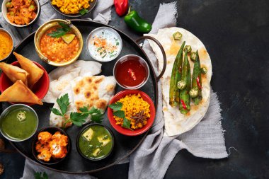 Indian Thali on dark background. Traditional food concept. Organic food concept. Dishes and appetisers of indeed cuisine. Top view, flat view, copy space