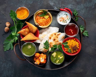 Indian Thali on dark background. Traditional food concept. Organic food concept. Dishes and appetisers of indeed cuisine. Top view, flat view