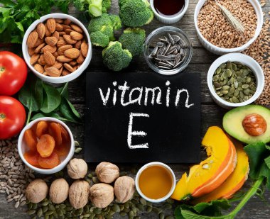 Rotik ahşap arka planda E vitamini bakımından zengin gıdalar. Sağlıklı ürünler. Üst görünüm, düz görünüm, yazı tahtası ile telif alanı