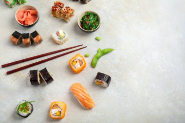 Hafif arka planda suşi çeşitleri. Geleneksel Japon lüks yemeği. Üst görünüm, düz görünüm, kopyalama alanı