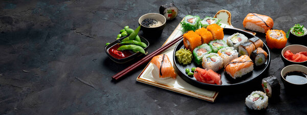 Sushi assortment on dark background. Japanese traditional luxury meal. copy space, panorama