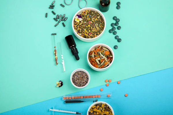 Assortment of herbal and traditional medicine on colourful background. Traditional healthcare concept. Natural homoeopathic remedies. Top view, flat lay, copy space