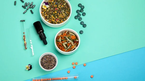 Assortment of herbal and traditional medicine on colourful background. Traditional healthcare concept. Natural homoeopathic remedies. Top view, flat lay, copy space