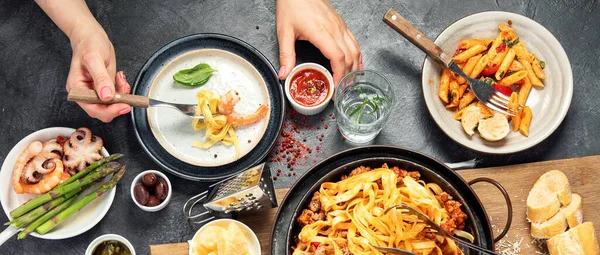 İtalyan yemekleri, makarna soslu makarna, mantı, tavuk soslu makarna, parmesan peyniri ve koyu arkaplanda su. Üst görünüm.