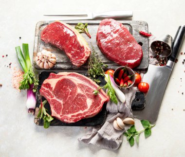 Baharatlı ve otlu lezzetli biftekler yapmak için taze çiğ et. Beyaz arka planda ızgara et için hazırlama, üst görünüm.