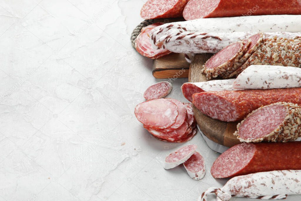 Sausages salami assortment on light background. Meat product made of finely chopped and seasoned meat. copy space