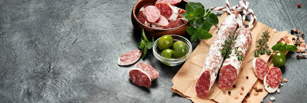 Traditional Spanish fuet on gray background. Dry cured pork sausages with peculiar taste. panorama