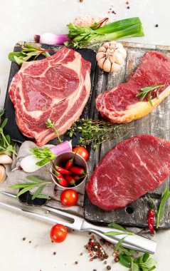 Baharatlı ve otlu lezzetli biftekler yapmak için taze çiğ et. Beyaz arka planda ızgara et için hazırlama, üst görünüm.