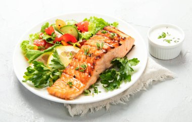 Sebzeli somon bifteği ve hafif arka planda patates kızartması. Taze ızgara. Sağlıklı bir akşam yemeği. Akdeniz Diyeti. 