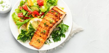 Sebzeli somon bifteği ve hafif arka planda patates kızartması. Taze ızgara. Sağlıklı bir akşam yemeği. Akdeniz diyeti. Üst görünüm, düz görünüm, kopyalama alanı