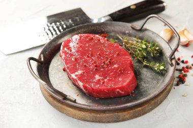 Biberli taze biftek ve ahşap tahtada sarımsak. Gri arkaplan, üst görünüm.