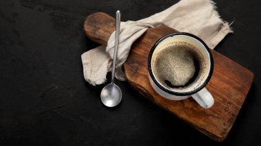 Koyu arkaplanda bir fincan koyu kahve. Sıcak içecek. Kahvaltı konsepti. Üst görünüm, düz görünüm, kopyalama alanı