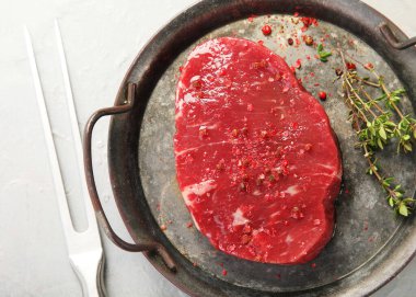 Biberli taze biftek ve ahşap tahtada sarımsak. Gri arkaplan, üst görünüm.