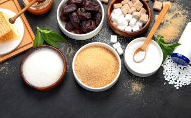 Koyu arkaplanda şeker için çeşitli diyet değişiklikleri. Organik tatlandırıcı konsepti. Üst görünüm, düz görünüm, kopyalama alanı