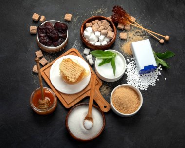 Various diet replacement for sugar on dark background. Organic sweetener concept. Top view, flat lay
