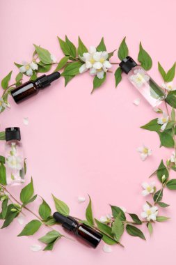 Yasemin çiçekli yağlı şişeler. Vücut ve yüz bakımı için doğal kozmetik ve güzellik ürünleri. Üst görünüm, düz görünüm, kopyalama alanı