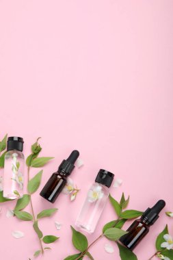 Yasemin çiçekli yağlı şişeler. Vücut ve yüz bakımı için doğal kozmetik ve güzellik ürünleri. Üst görünüm, düz görünüm, kopyalama alanı