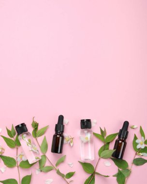 Yasemin çiçekli yağlı şişeler. Vücut ve yüz bakımı için doğal kozmetik ve güzellik ürünleri. Üst görünüm, düz görünüm, kopyalama alanı