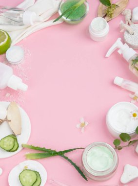 Pembe arka planda yüz ve vücut bakım ürünleri. Doğal kozmetikler. Üst görünüm, düz görünüm, kopyalama alanı