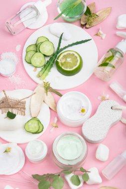Pembe arka planda yüz ve vücut bakım ürünleri. Doğal kozmetikler. Üst manzara, düz uzanma