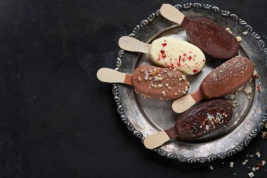 Esmer arka planda buzlu dondurma çeşitleri. Bahar doğal arka plan. Üst görünüm, düz görünüm, kopyalama alanı