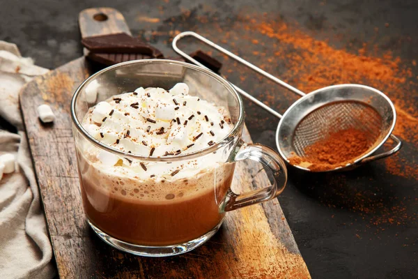 Cacao with marshmallow and cacao powder in mug. Hot beverage with whipped cream.