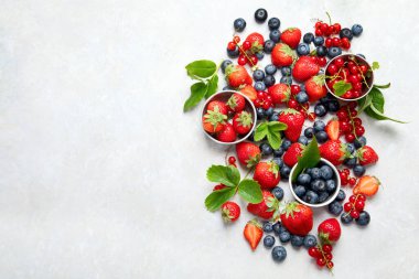 Various fresh berries on neutral background. Organic valuable food source. Top view, copy space