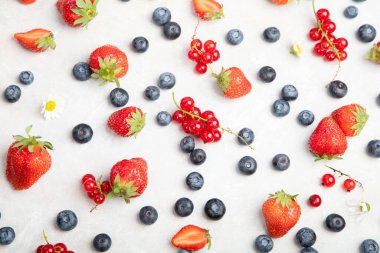 Various fresh berries on neutral background. Organic valuable food source. Top view, copy space