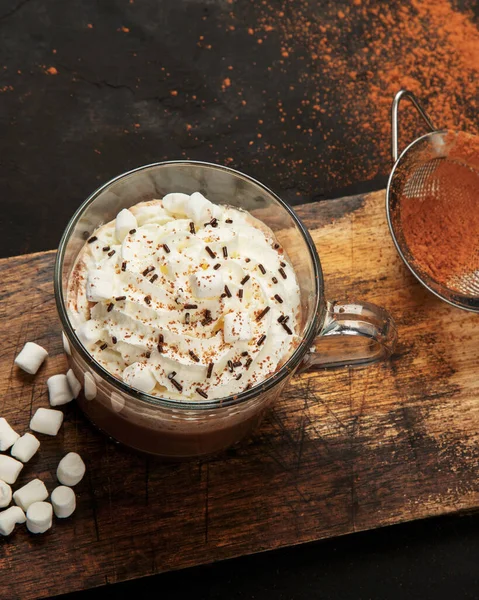 Cacao with marshmallow and cacao powder in mug. Hot beverage with whipped cream. Top view, flat lay, copy space