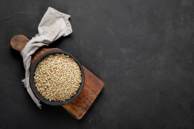 Raw green buckwheat on dark background. Food ingredients. Concept of organic food. Top view, copy space