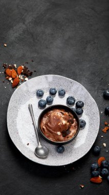 Chocolate ice cream with berries on dark background. Top view, copy space