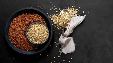 Raw green buckwheat on dark background. Food ingredients. Concept of organic food. Top view, copy space