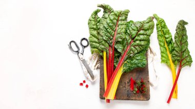 Raw chard on light background. Highly nutritious leaves. Popular component of healthy diets. Top view, copy space